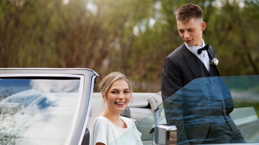 A girl and a boy arrived to the prom party in their special prom car